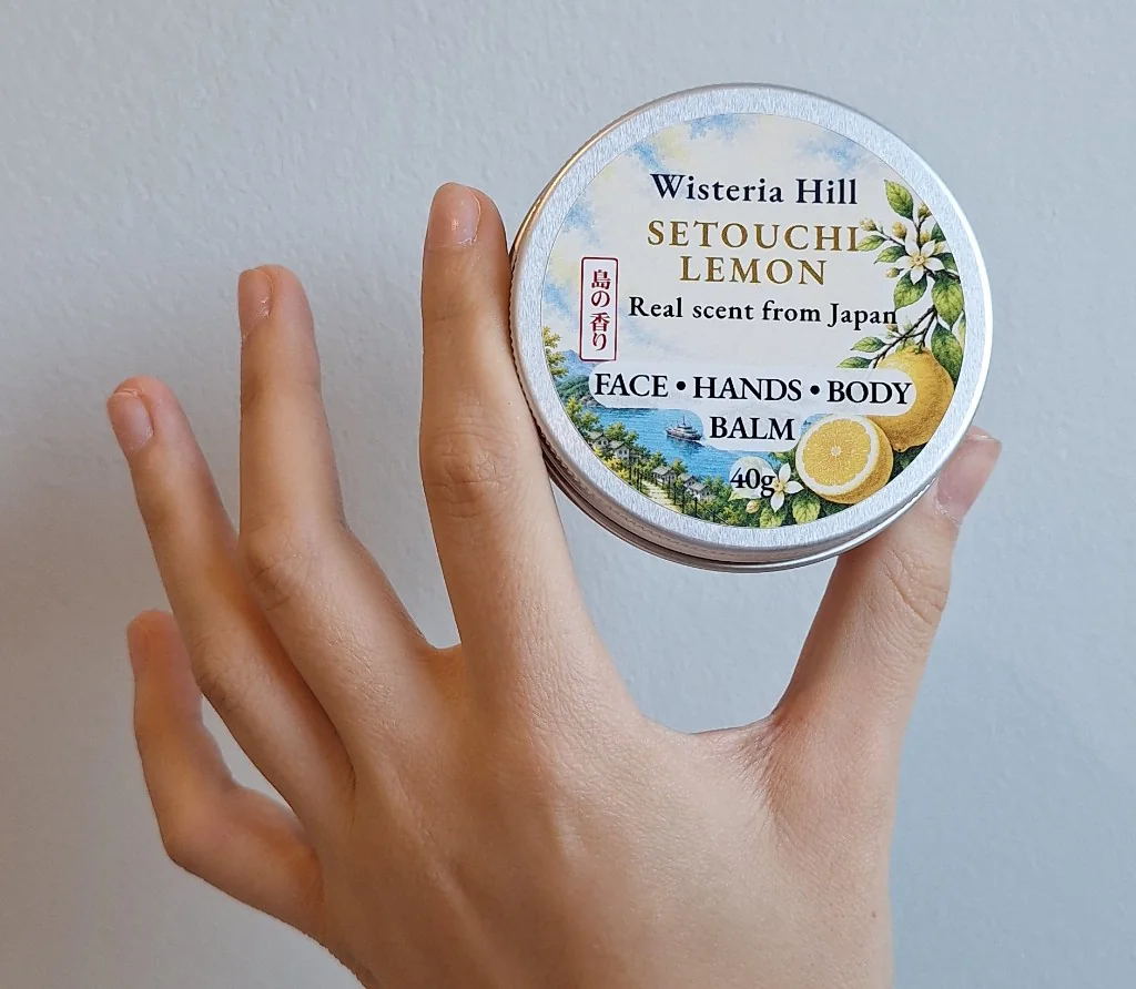 Hand holding a tin of Wisteria Hill Setouchi Lemon balm